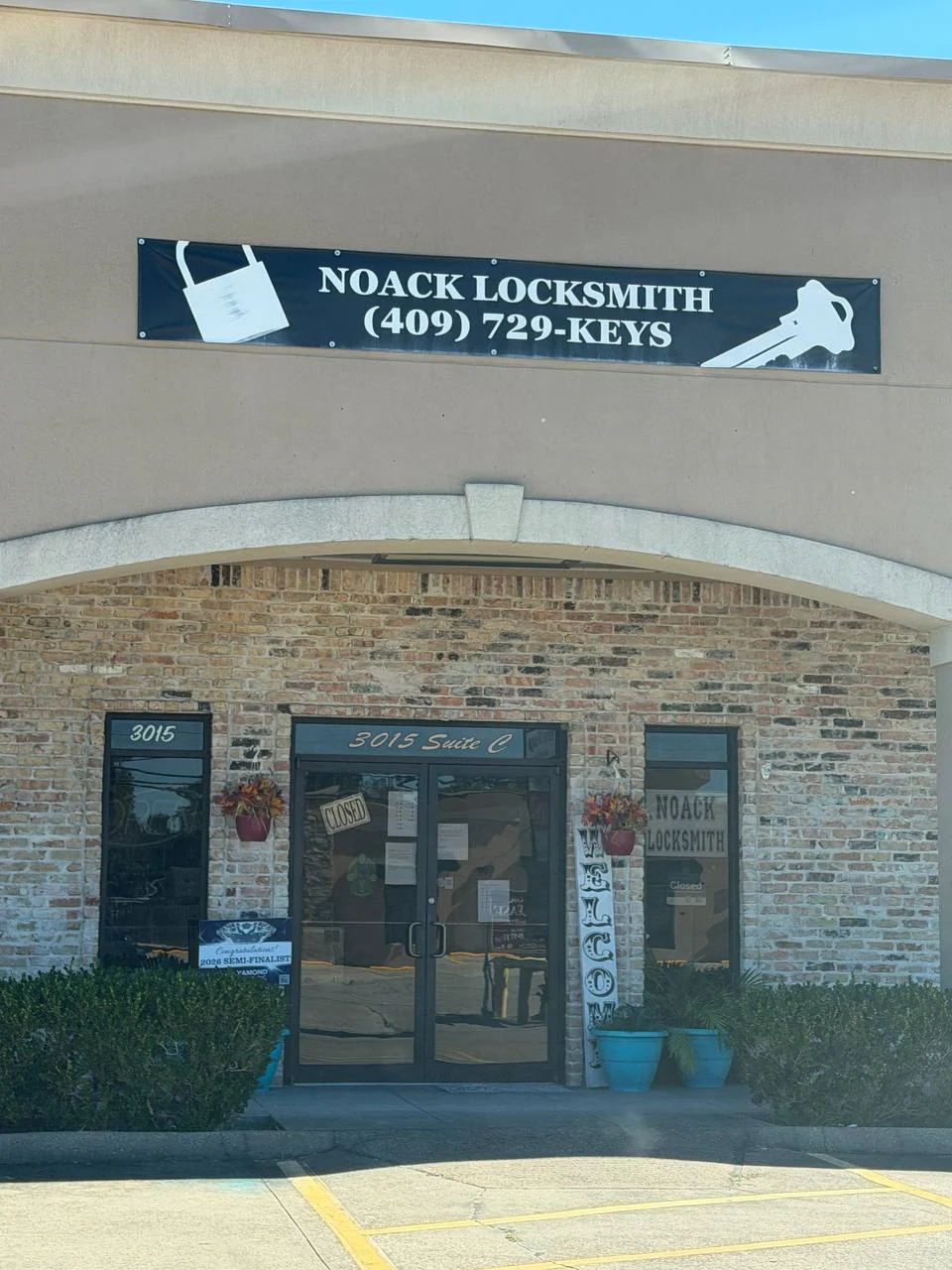 Noack Locksmith's brick storefront, business sign, and entrance marked 3015 Suite C on Nederland Avenue.